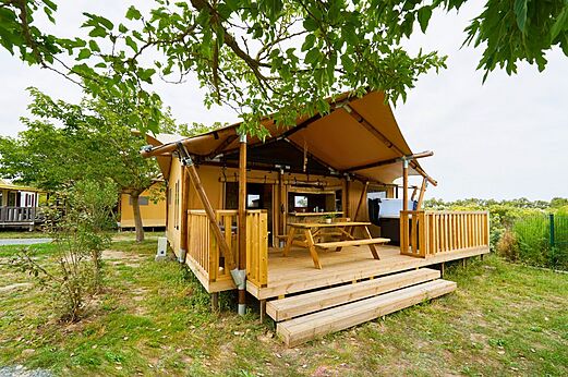 Tienda lodge con terraza y mesa en camping CLICOCHIC Seulières Saint-Denis-d'Oléron (17).