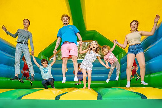 Ni�os y animador saltando en juego inflable en el camping VAGUES OCEANES Soleil de Provence.