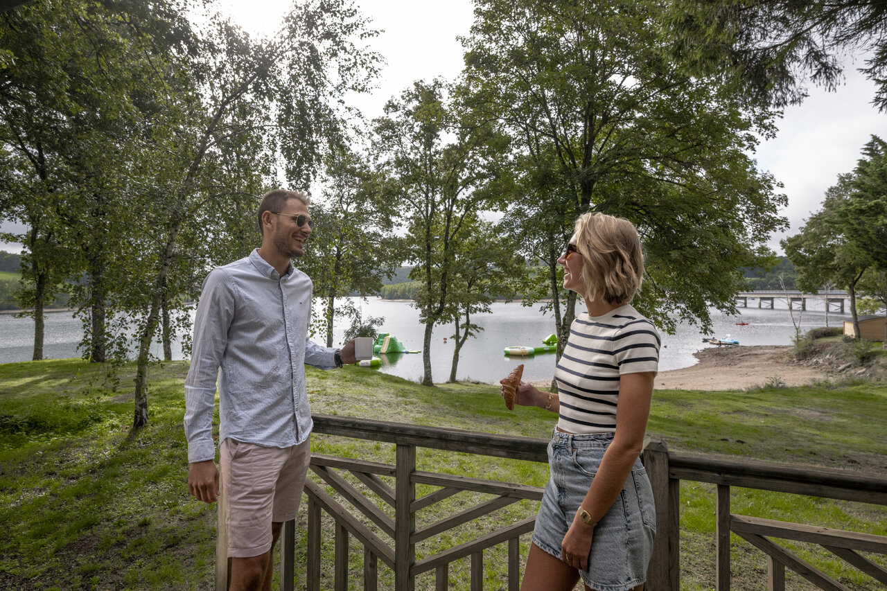 Pareja en terraza, lago, actividades n�uticas en el camping CLICOCHIC Soleil Levant en Canet-de-Salars.