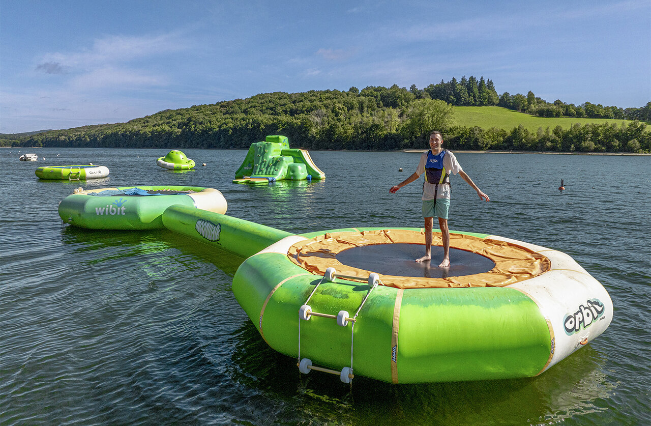 Trampol�n flotante, parque acu�tico en lago en camping CLICOCHIC Soleil Levant.