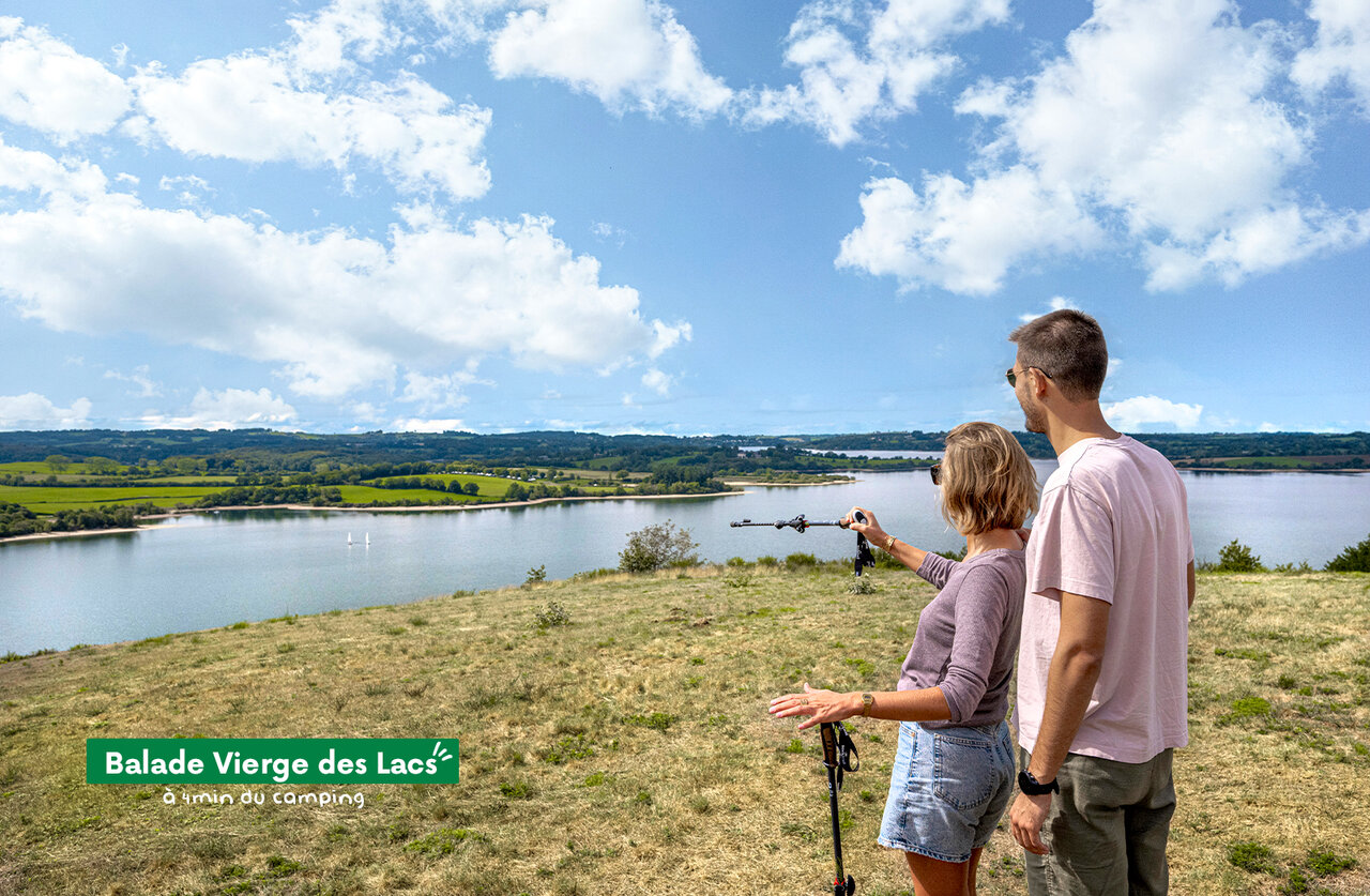 Pareja de senderistas admirando el lago y el paisaje en Balade Vierge des Lacs.