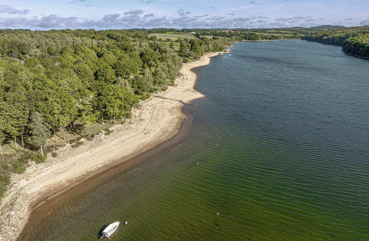 Playa lacustre, bosque en el camping CLICOCHIC Soleil Levant en Canet-de-Salars (12).