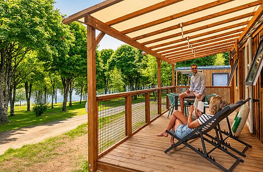 Mobil-home con terraza cubierta y pareja en CLICOCHIC Soleil Levant, Canet-de-Salars (12).