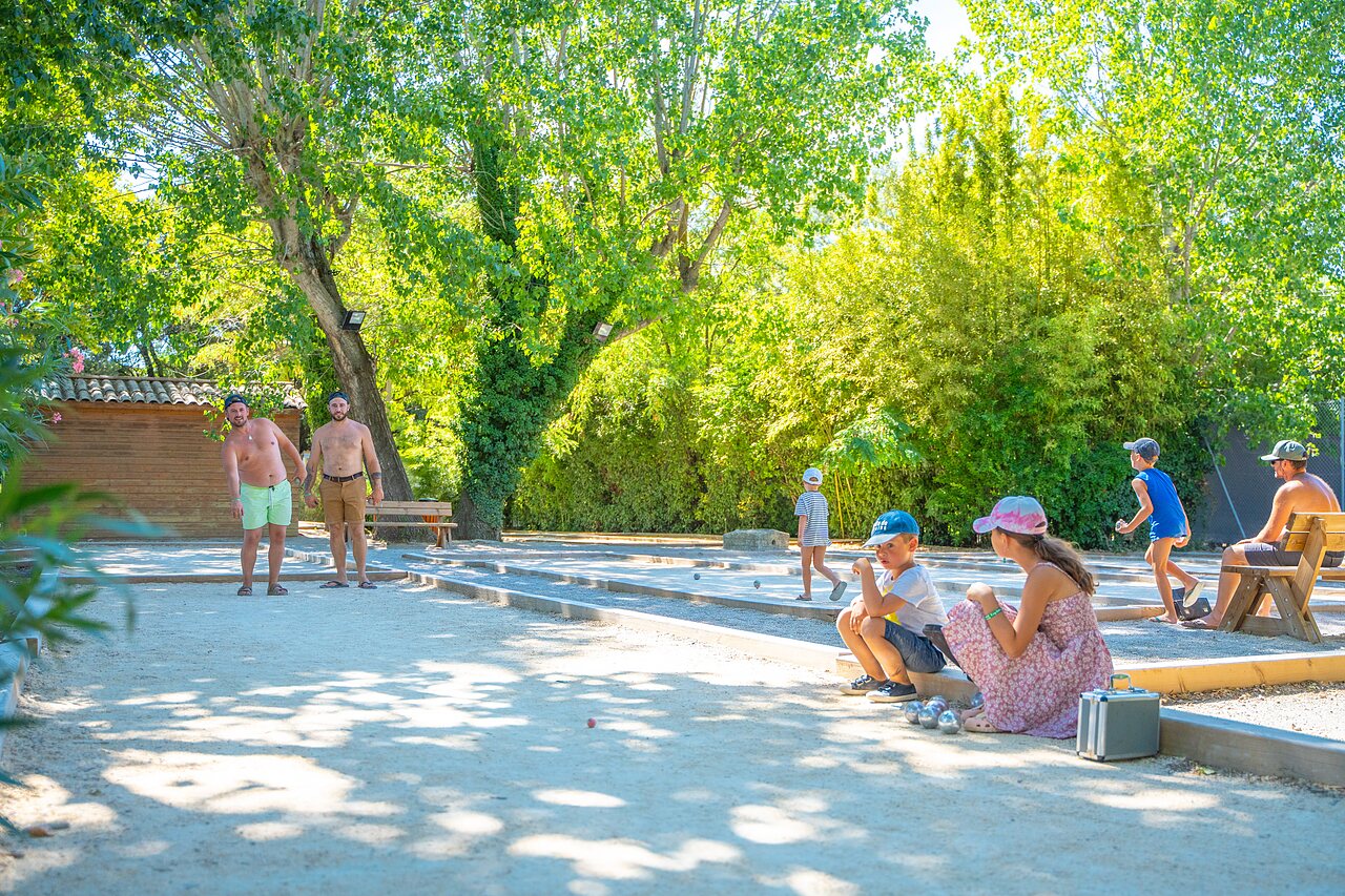 Juego de petanca familiar a la sombra en el camping CAPFUN Soubeyranne en REMOULINS (30).