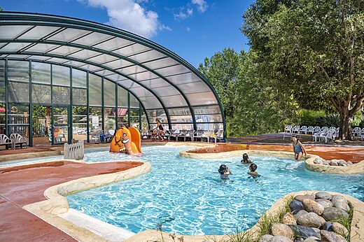 Piscina exterior con tobogán elefante y niños, en el camping CAPFUN Soubeyranne en REMOULINS (30).