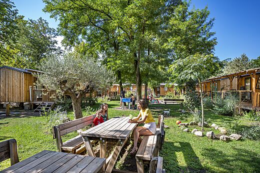 Mobil-homes de madera, familias relajándose en el camping CAPFUN Soubeyranne en REMOULINS.