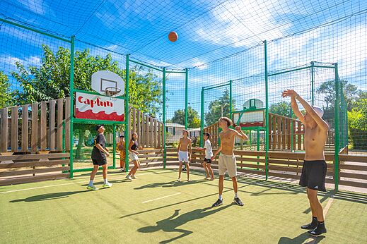Cancha multideportiva de baloncesto con jóvenes en el camping CAPFUN Soubeyranne (30).