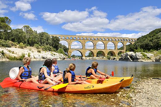 Familia en kayak en el río con acueducto romano en el camping CAPFUN Soubeyranne en REMOULINS (30).