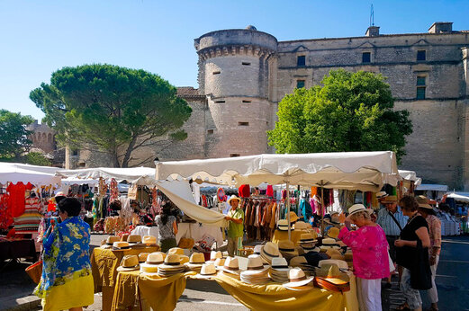 Animado mercado provenzal frente al castillo de Gordes, pueblo para visitar en Provenza.