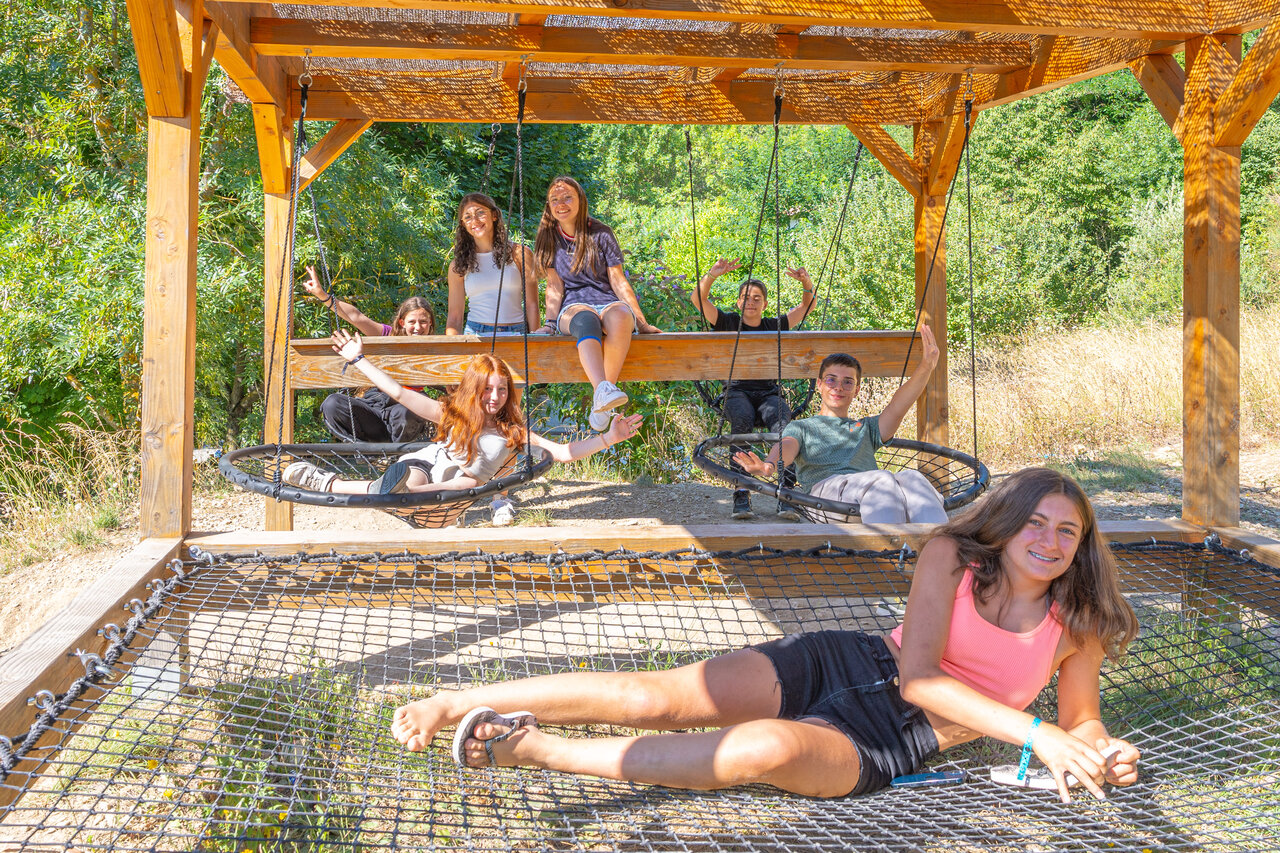 J�venes en columpios y red de juegos en el camping CLICOCHIC Source du Jabron en Comps (26).