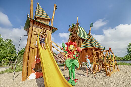 Zona de juegos de madera con tobogán y niños en el camping CLICOCHIC Source du Jabron en Comps (26)
