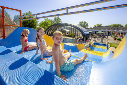 Tobog�n acu�tico gigante y ni�os sonrientes en el camping CAPFUN De Sprookjescamping en Rheeze.