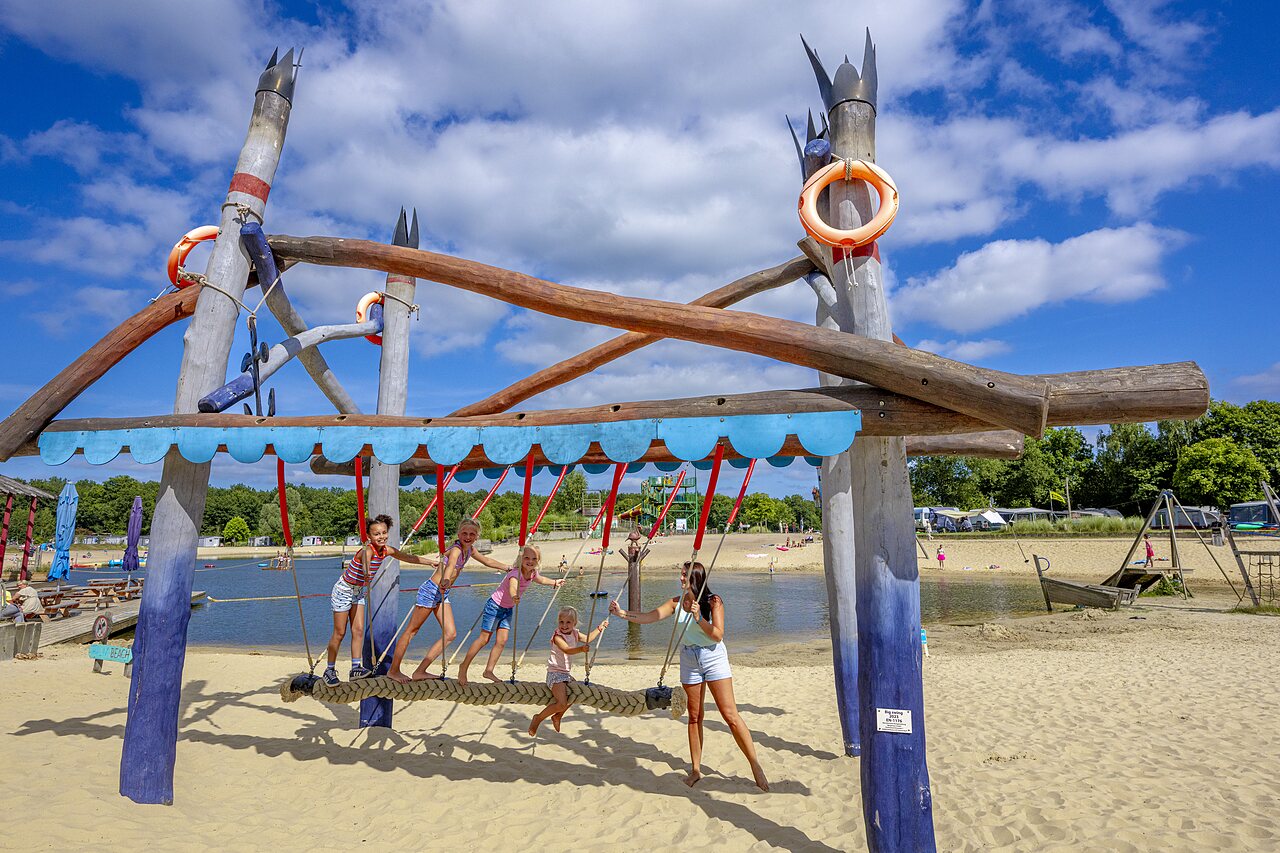 Estructura de juegos de madera en la playa de arena con ni�os en el camping CAPFUN Vakantiepark Capfun het Stoetenslagh en Rheezerveen.