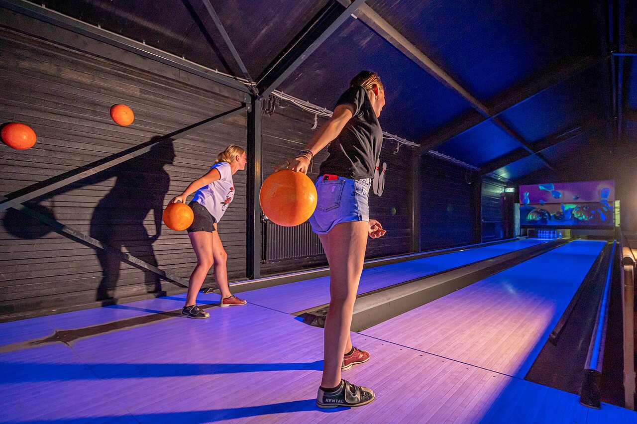 J�venes divirti�ndose jugando a los bolos en pistas luminosas en el camping CAPFUN Vakantiepark het Stoetenslagh en Rheezerveen.