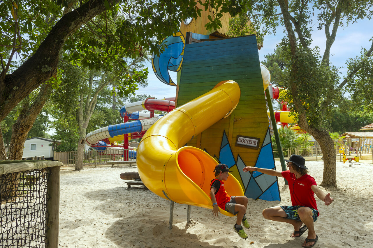 Tobog�n amarillo y ni�o con animador en el camping CAPFUN Sud Land en Labenne-Ocean.