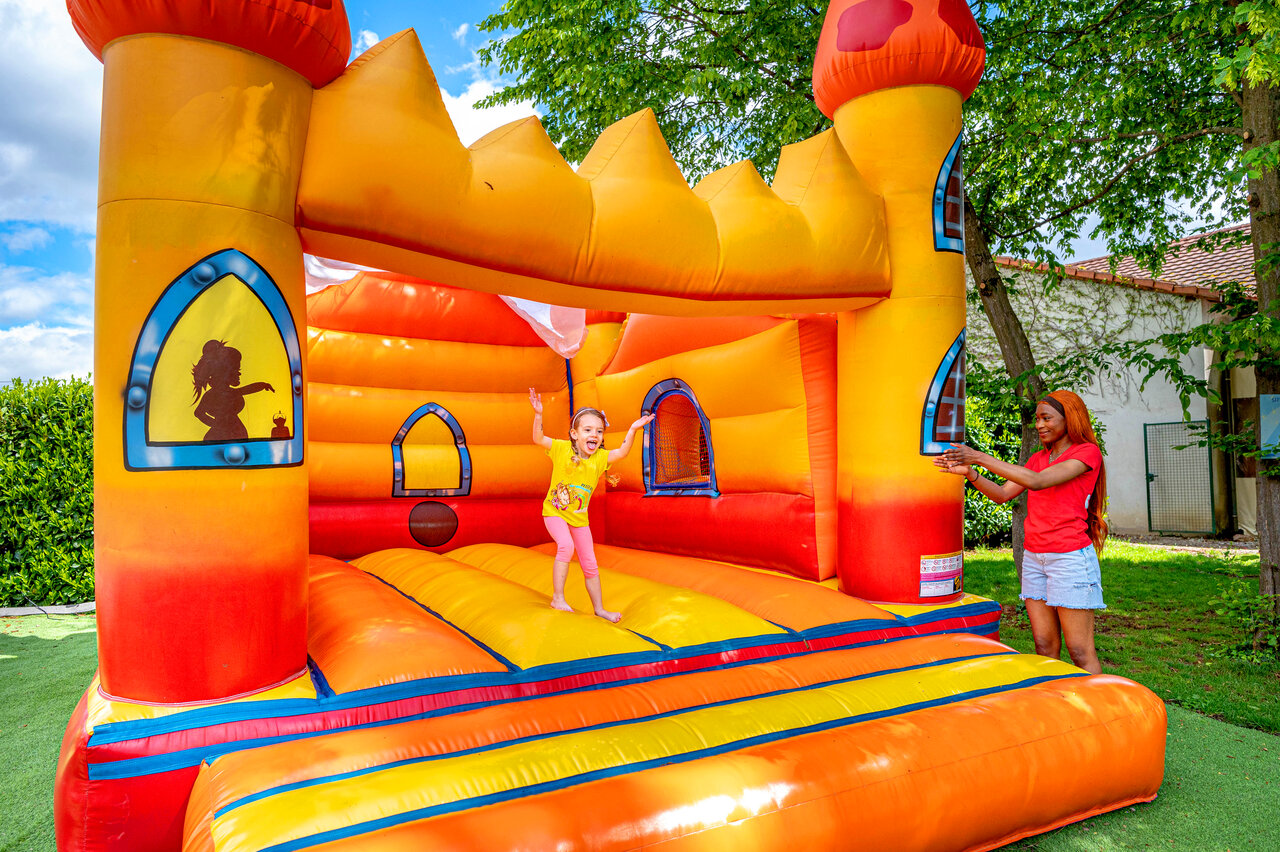 Castillo hinchable colorido con ni�o y animador en el camping CAPFUN Suzel en Sainte-Croix-en-Plaine (68).