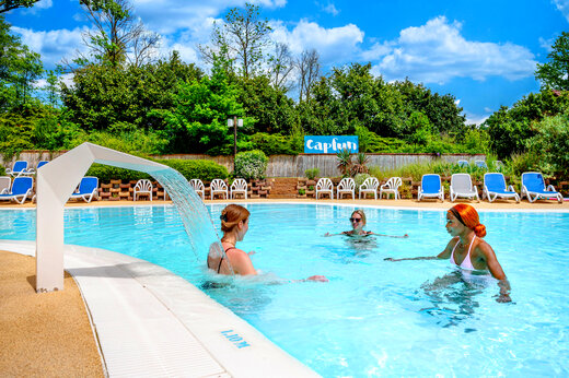 Piscina exterior con cascada en el camping CAPFUN Suzel en Sainte-Croix-en-Plaine (68).