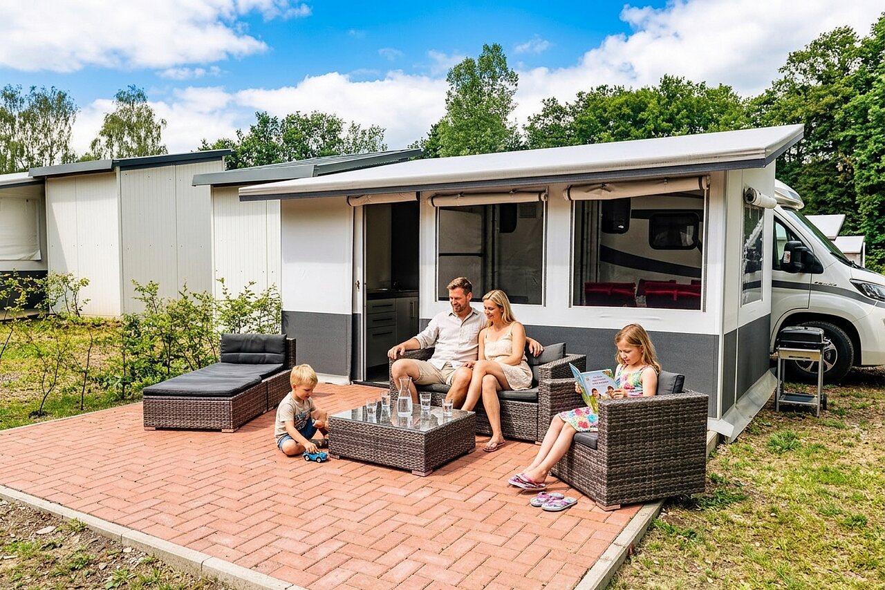 Familia relajada en la terraza de una casa m�vil en el camping CAPFUN Tecklenburg en Tecklenburg-Leeden (49).