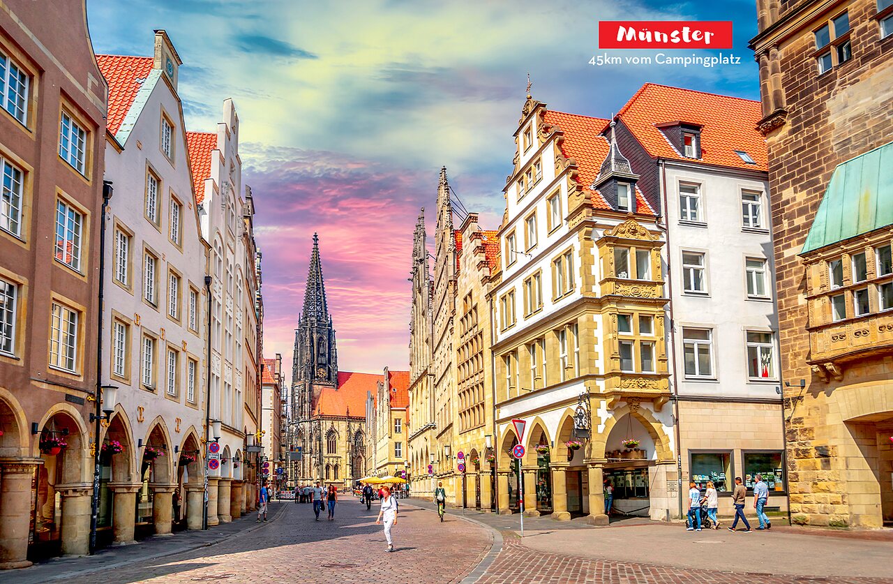 Calle hist�rica animada de M�nster con fachadas tradicionales e imponente iglesia g�tica.