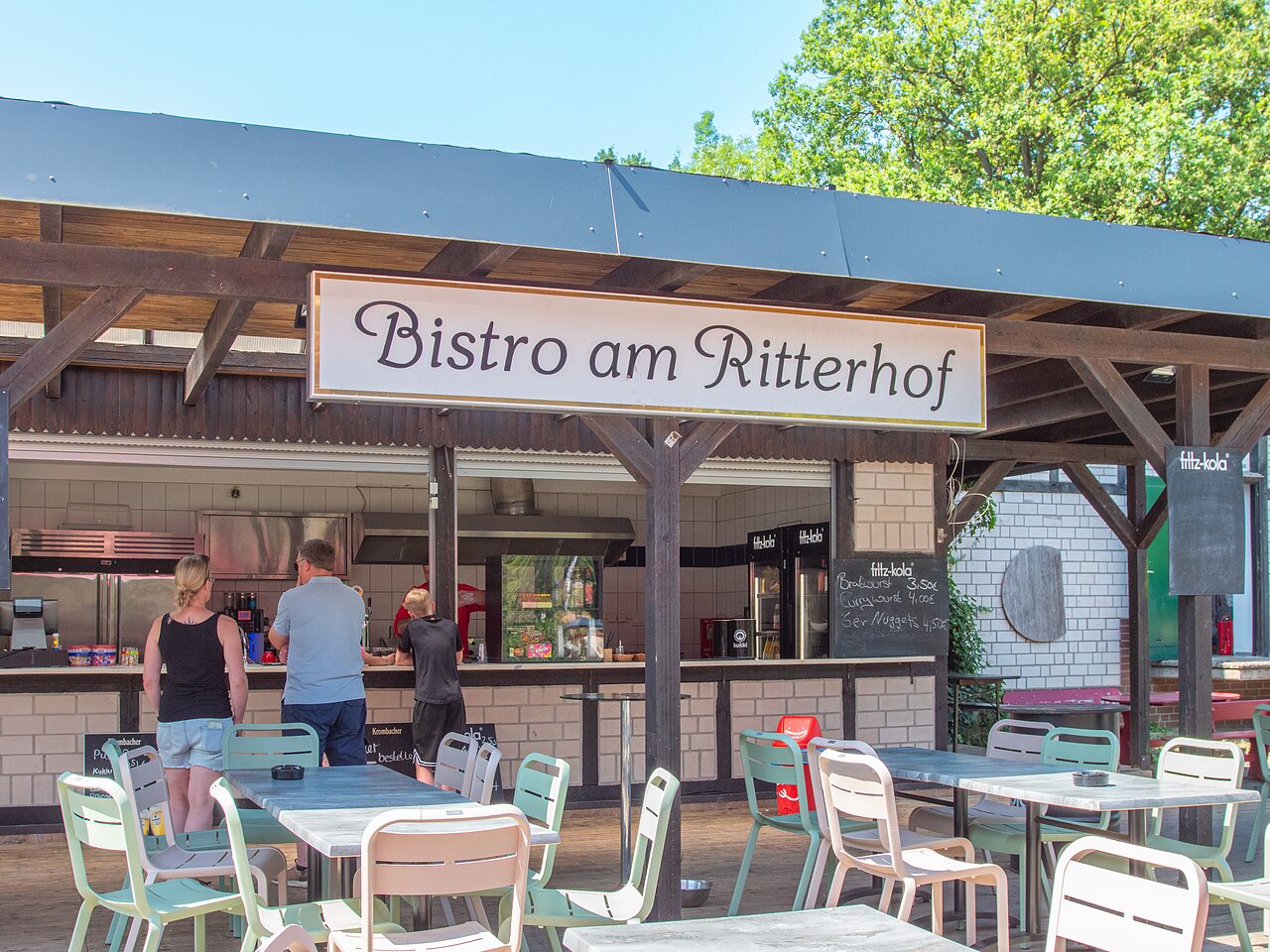 Bistr� exterior y mesas de restaurante en el camping CAPFUN Tecklenburg en Tecklenburg-Leeden (49).