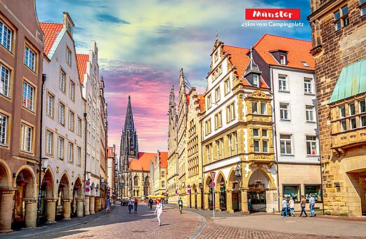 Calle hist�rica con edificios tradicionales y catedral en M�nster, Alemania.