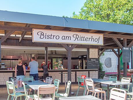 Bistr� exterior y mesas de restaurante en el camping CAPFUN Tecklenburg en Tecklenburg-Leeden (49).