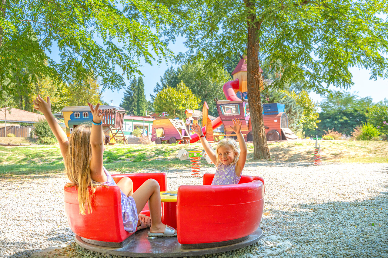 Ni�os en carrusel, zona de juegos en el camping CAPFUN Temps Libre en BOUGE CHAMBALUD (38).