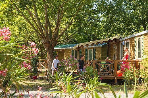 Mobil-homes de madera con terraza y familia en CAPFUN Temps Libre en BOUGE CHAMBALUD (38).