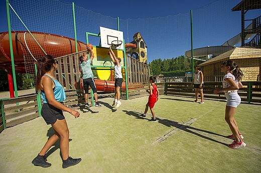 Jugadores de baloncesto en cancha multideporte en camping CAPFUN Temps Libre en BOUGE CHAMBALUD (38).
