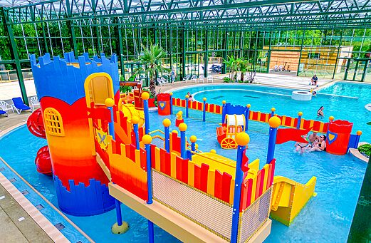 Piscina cubierta con juegos acuáticos infantiles en el camping CAPFUN Tensch Jolie en Grostenquin (57).