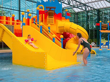 Juegos acuáticos y toboganes coloridos en la piscina del camping CAPFUN Tensch Jolie.