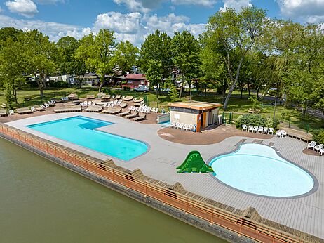 Piscina exterior, piscina infantil, tobogán dinosaurio, sillas en el camping CAPFUN Tensch Jolie.