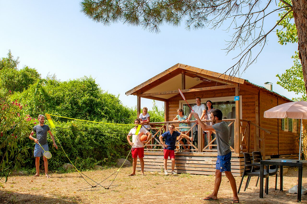 Mobil-home de madera, familia jugando b�dminton en camping CAPFUN Teorix en MARSEILLAN PLAGE.