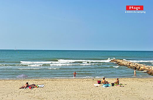 Playa de arena fina con mar, olas y ba�istas en el camping CAPFUN Teorix en MARSEILLAN PLAGE (34).