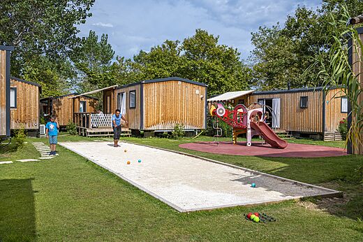 Cancha de petanca con jugadores y Mobil-homes en camping CAPFUN Teorix MARSEILLAN PLAGE.