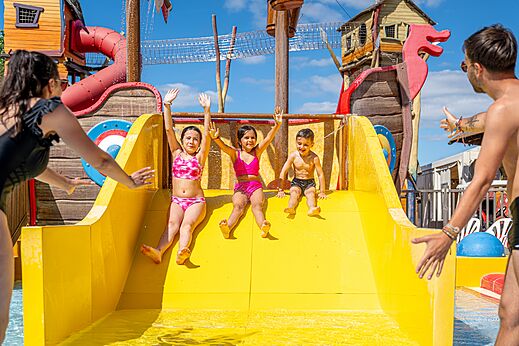 Ni�os desliz�ndose tobog�n acu�tico amarillo en camping CAPFUN Teorix en MARSEILLAN PLAGE (34).