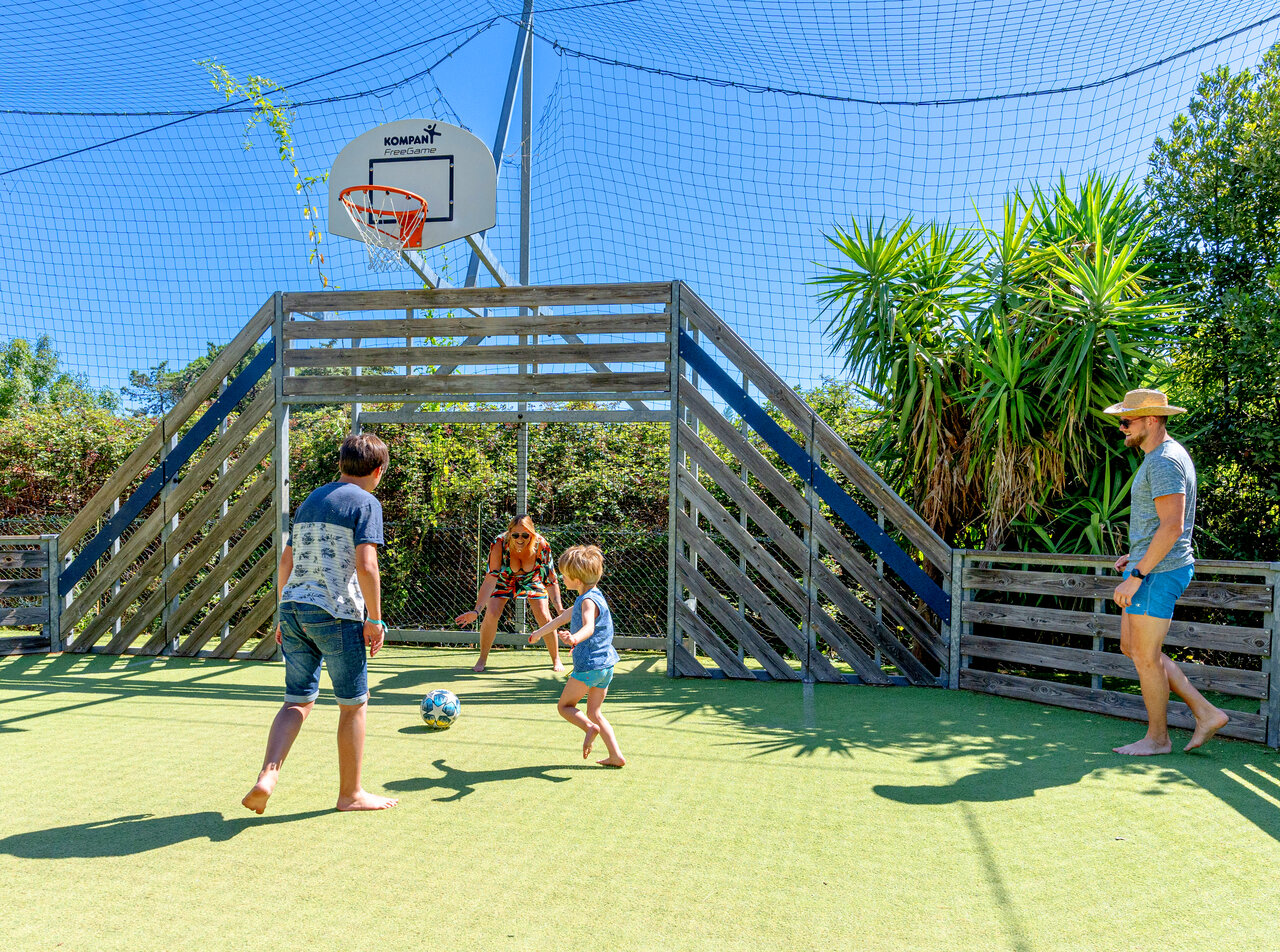 Familia juega f�tbol en campo multideportivo en camping CLICOCHIC Texas, Argel�s.