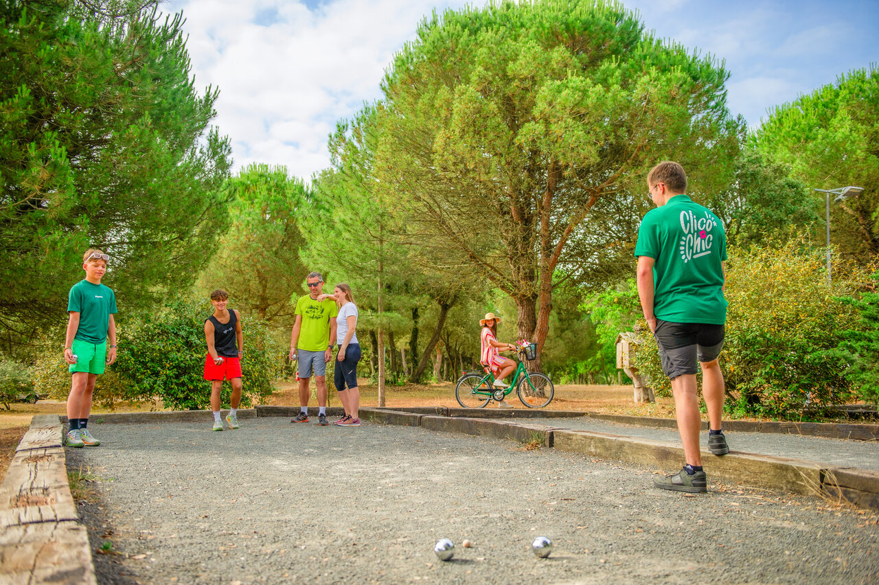 Familia y amigos jugando a la petanca en el camping CLICOCHIC Plage des Tonnelles.
