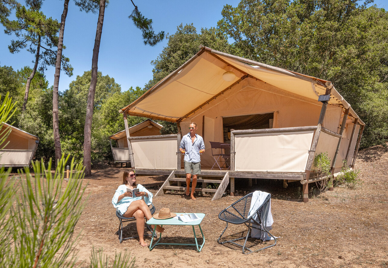 Pareja relaj�ndose en tienda lodge glamping en camping CLICOCHIC Plage des Tonnelles (85).