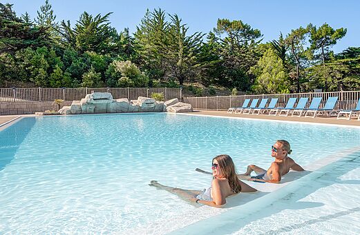 Piscina exterior con cascada en el camping CLICOCHIC Plage des Tonnelles.