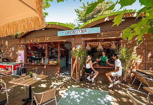 Bar La Cabana y terraza de madera en camping CLICOCHIC Plage des Tonnelles.