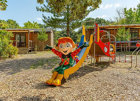 Mascota en tobogán del parque infantil en el camping CLICOCHIC Plage des Tonnelles.