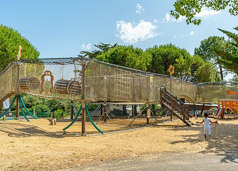 Parque infantil con estructura de red en el camping CLICOCHIC Plage des Tonnelles.