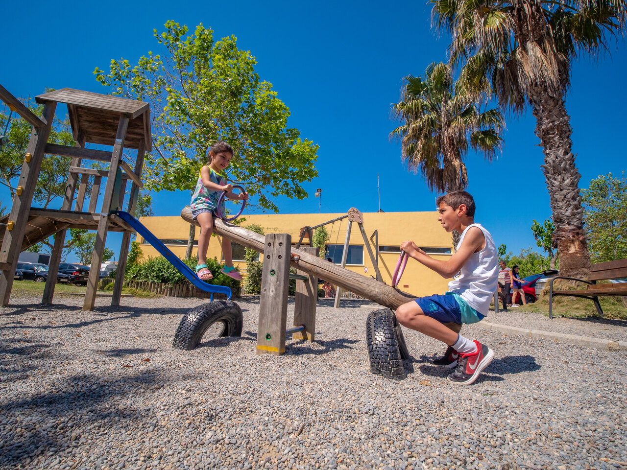 Zona de juegos con ni�os en balanc�n en el camping CAPFUN Tordera-Nacions en Malgrat de Mar.