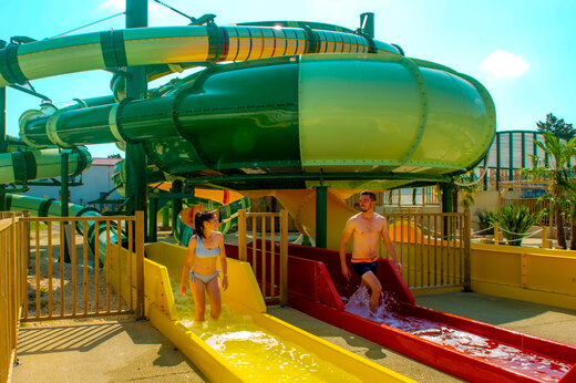 Toboganes acuáticos coloridos y personas divirtiéndose en el camping CAPFUN Celeste en Breuillet (17).