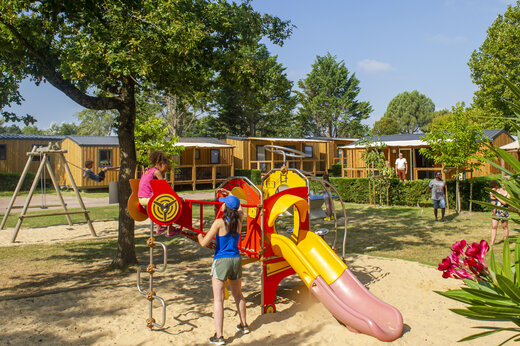 Parque infantil con tobog�n y Mobil-homes en el camping CAPFUN Celeste en Breuillet (17).