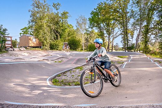 Ni�o en bicicleta en la pista de pump track del camping CLICOCHIC Trelachaume en Maisod (39).