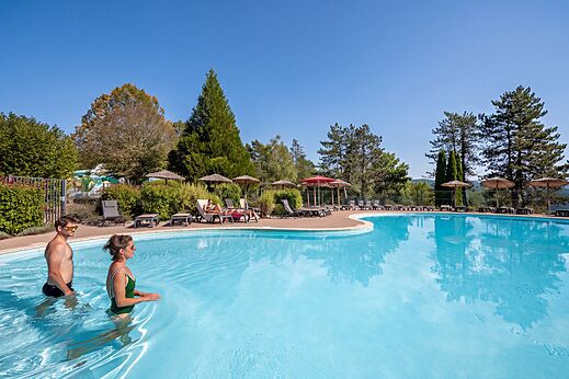 Gran piscina exterior con ba�istas y tumbonas en el camping CLICOCHIC Trelachaume en Maisod (39).