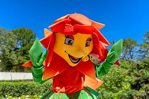 Mascota flor sonriente con abeja para animación en el camping CLICOCHIC Trelachaume (39).