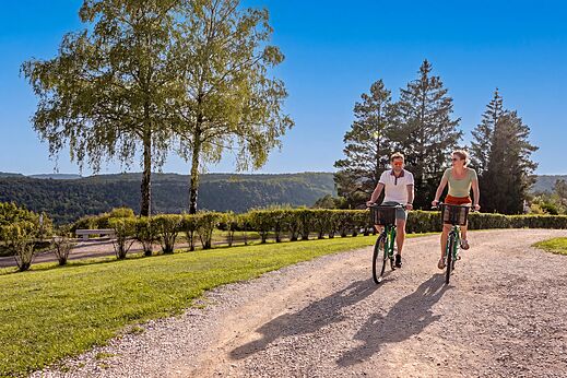 Pareja en bicicleta por sendero del camping CLICOCHIC Trelachaume en Maisod (39).